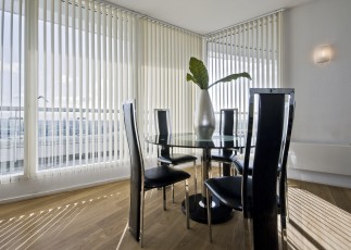 stylish modern dining room with a round glass top table and seats for five